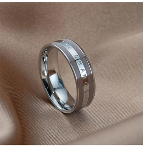 Macro shot of stainless steel wide ring featuring engraved THE CHANGE text on silk