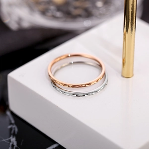 Anillos minimalistas de acero de titanio de 1 mm en oro rosa y plata en base blanca