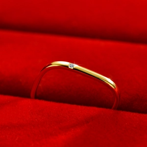 Minimalistische golvende gouden ring met glanzend kristal op rode fluwelen doos