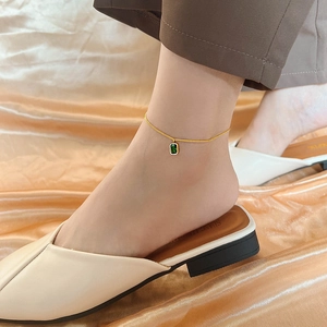 18K gold plated anklet with green crystal emerald cut pendant on satin background
