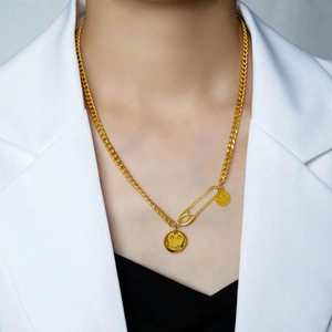 Hip hop gold necklace featuring safety pin and smile pendants on a layered curb chain