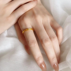 Elegant gold titanium steel ring with engraved lettering on model's hand
