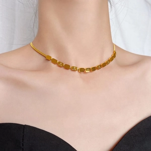 Chique 18K vergulde slangenketting met gegraveerde love-blokjes gedragen door een model
