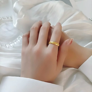 Bague classique dorée avec motif en nid d'abeille ajouré sur fond de soie blanche élégante