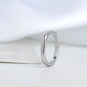 Macro shot of silver titanium ring with Je t'aime engraving and geometric facets