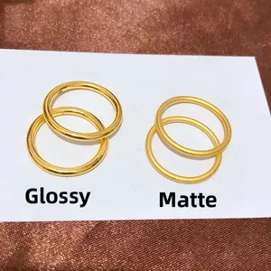 Minimalistische Goldringe aus Titanstahl in glänzender und matter Optik auf Seidenstoff