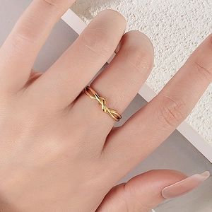 Minimalist knot ring in 18k gold plated stainless steel worn on finger for display