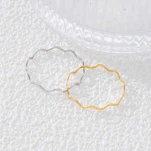 Anelli minimalisti a onde in oro 18 carati e argento su sfondo strutturato