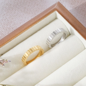 Minimalist striped gold and silver titanium rings displayed on a velvet jewelry box