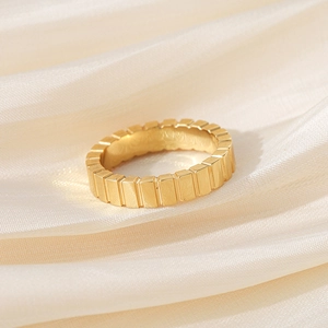 Detailed view of the vertical grooved texture on the gold-plated titanium steel ring