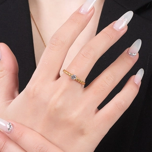 Primer plano de un anillo trenzado dorado con circonita brillante en una modelo