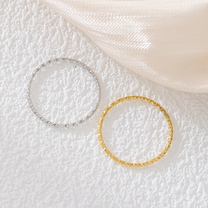 Anelli minimalisti da 1mm in acciaio al titanio oro e argento su pietra e raso