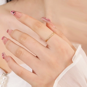 Minimalistischer goldener Titanring mit acht Zirkonsteinen an der Hand zum Stapeln