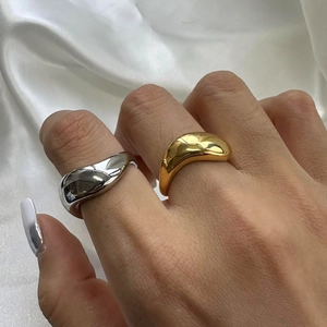 Anelli bombati dal design organico in oro 18 carati e argento su raso bianco
