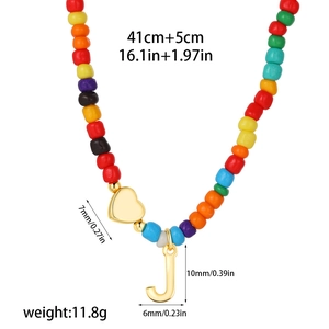 Detail view of rainbow beaded necklace with golden heart and letter J pendant charms
