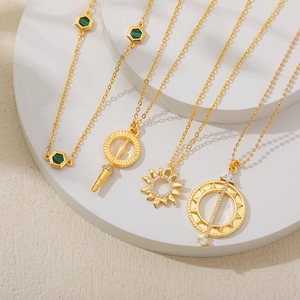 18K gold plated stainless steel necklaces with compass and zircon pendants on stone