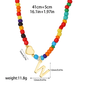 Detailed view of colorful beaded necklace featuring a 14k gold heart and letter W pendant