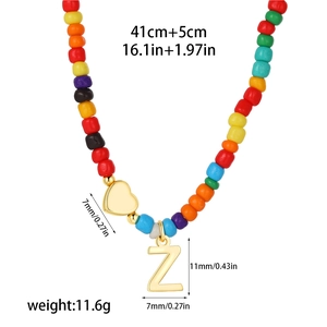 Detail of multi-color beads with golden heart and Z letter pendant on 14k gold necklace