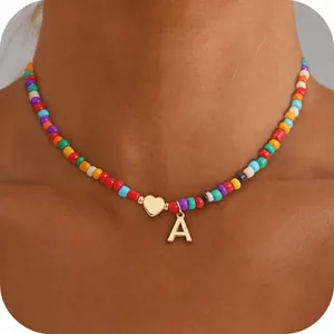 Close-up of 14k gold heart and letter A pendant on colorful beaded rainbow necklace