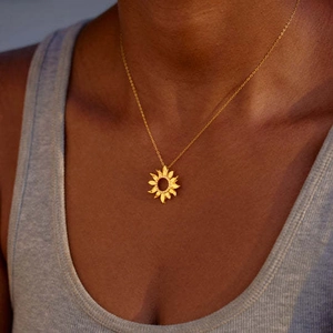 Detailed close-up of a 18K gold plated sunflower pendant necklace on a female model