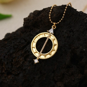 Detail of 18K gold compass pendant necklace with zircon and mother of pearl on dark rock