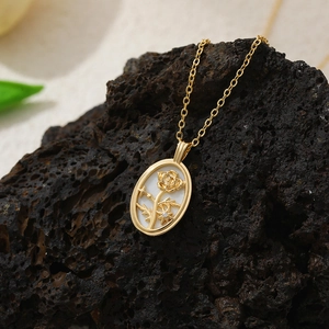 Gros plan du pendentif rose en or 18 carats avec nacre blanche sur roche volcanique