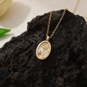Vue macro d'un collier pendentif ovale en or 18K avec nacre blanche et motif floral