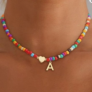 Colorful beaded necklace with 14k gold plated heart and letter A pendant on model