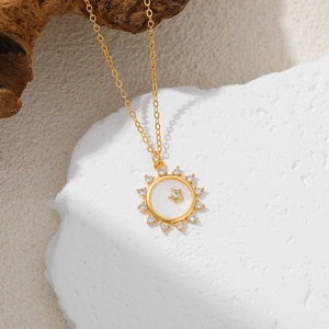 Detail of 18K gold starburst pendant with white mother of pearl and sparkling zircon