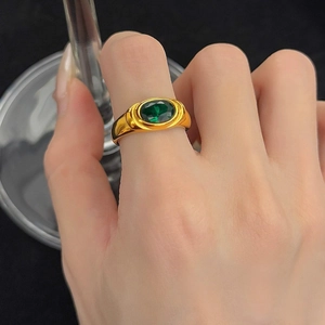Vintage 18K gold ring with oval green zircon, elegantly worn on a hand in high-detail macro