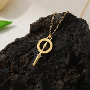 Close-up of 18K gold plated compass pendant necklace with zircon detail on volcanic stone