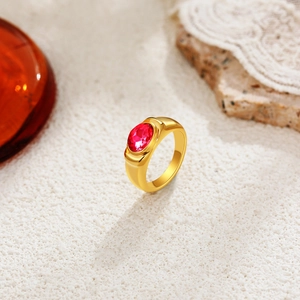Detailed close-up of 18K gold ring featuring an oval red gemstone in bezel setting