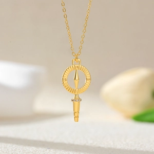 Macro shot of 18K gold plated compass pendant with white zircon and engraved N S E W letters