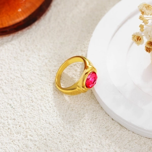 Macro view of wide 18K gold ring featuring a large oval red gemstone in bezel setting