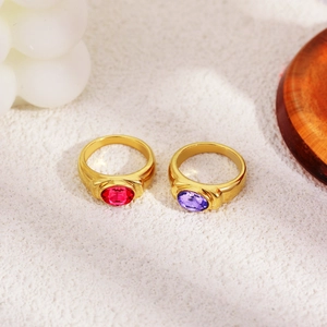 Macro view of 18K gold plated rings featuring oval red and purple gemstone settings