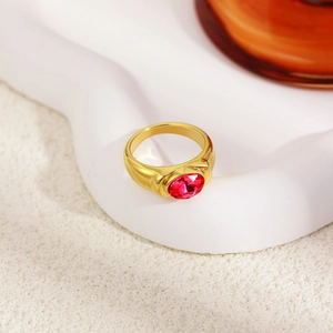 Macro view of vintage 18K gold ring with large oval red gemstone on textured background