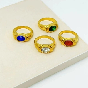 Set of four 18K gold vintage rings with emerald, ruby, sapphire, and clear gemstones