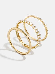 Macro detail of three 18K gold stackable rings with marquise and baguette zircon stones