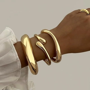 Three-piece set of 14K gold plated chunky open bangles and a croissant dome ring on model