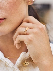 Macro view of three-piece 18K gold plated stackable rings with zircon insets on a finger