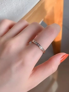 Detailed view of rose gold band ring with micro-pave white zircons on female finger