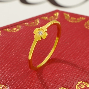 Makroaufnahme Goldener Kleeblattring mit Diamanteinlage auf elegantem rotem Hintergrund