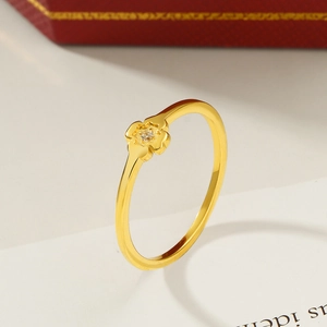 Klassischer goldener Kleeblatt-Ring mit funkelndem Diamant auf einer roten Schmuckschatulle
