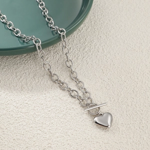 Detail of silver heart pendant necklace with oval link chain and toggle clasp