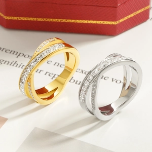 Überkreuzte Zirkonia Ringe in Silber und Gold auf einer roten Schmuckschatulle gesetzt