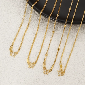 Various 24K gold-plated titanium steel necklaces with snake and box chains on black plate