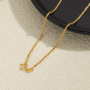 Elegantly textured 24K gold plated titanium steel chain necklace on a black matte tray