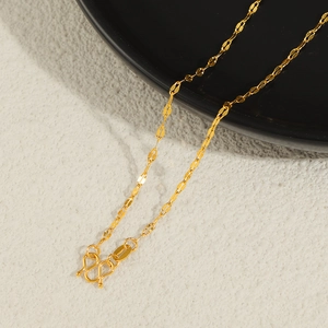 Close-up of a 24K gold plated titanium leaf-shaped chain with a classic M-clasp closure