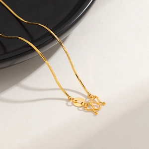 Detail view of 24K gold plated snake chain with elegant S-hook clasp and metal tag