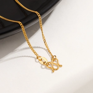 Macro view of 24K gold-plated titanium steel curb chain with classic M-shaped clasp
